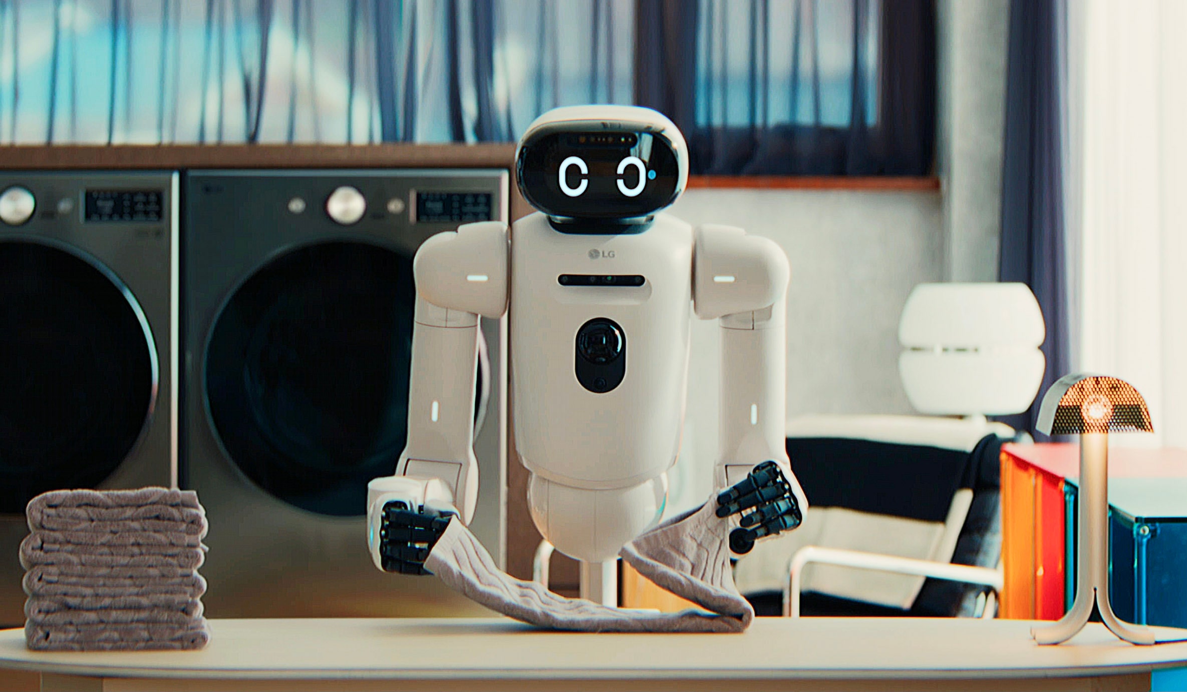 LG CLOiD robot folding a towel beside laundry appliances